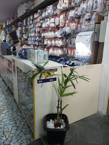 Balcão da loja com parede de ferragens e itens de fixação embalados